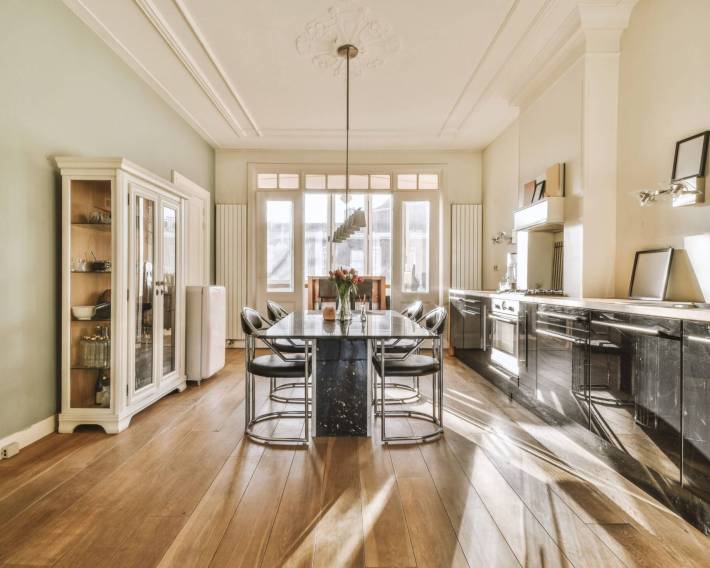 Beautiful kitchen and dining room with shelf and table in the centre