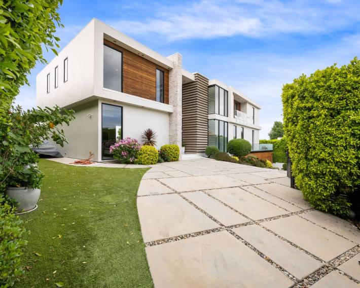 A Driveway of a contemporary house with a garden area